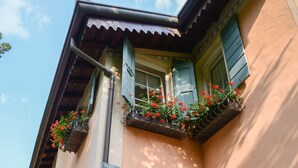 A building with a sloped roof, multiple windows with shutters, and flower boxes on the exterior walls. - Hotel Villa Rosenhof 1893 (Gardone Riviera)