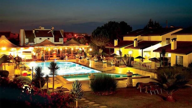 Resort com piscina, área de estar externa e vários edifícios.