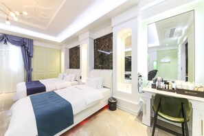 Quarto de hotel com duas camas, uma toucador com espelho e uma escrivaninha com amenities.