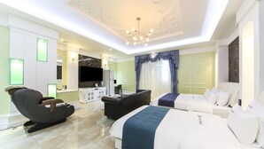 A modern hotel room with a large bed, a sofa, a massage chair, and a TV. - Myeongpum Drive-in Hotel (Jeongeup)