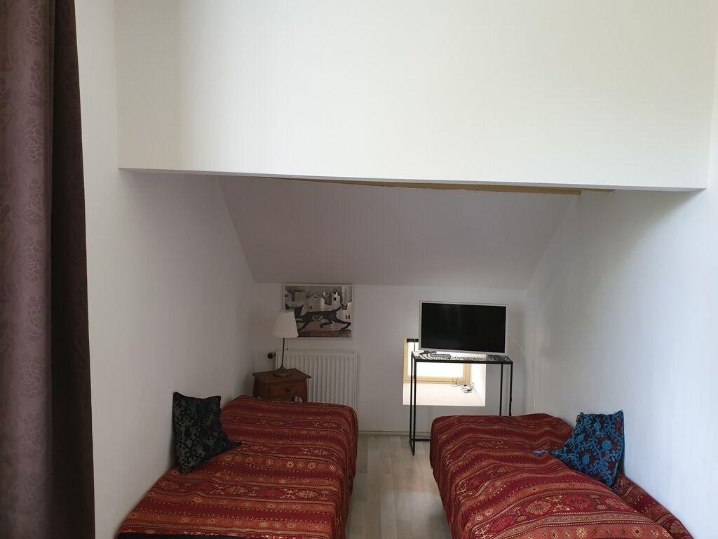 Ein Schlafsaalzimmer mit zwei Betten, einem Schreibtisch, einem Fernseher und einem Fenster.
