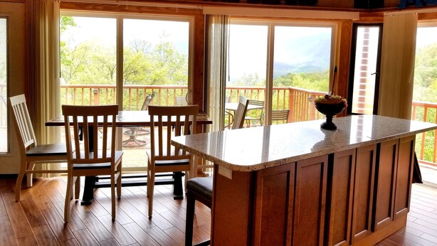 A cozy room with a wooden ceiling, a bar area, and large windows offering a view of the outdoors. - Mountain View/2 King Suites/Hot Tub/Pool Table/Minutes to Ober & Downtown (Gatlinburg)