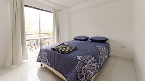 Ein Schlafzimmer mit einem Bett, Kissen und einem Tisch am Fenster.
