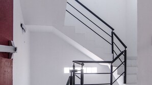 Eine moderne Treppe mit schwarzen Geländern und weißen Wänden, die zu einer oberen Etage führt.