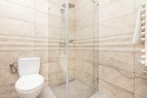 A bathroom with a glass-enclosed shower, a toilet, and a towel rack. - Business Mokotow Park 214 Apartment (Warsaw)