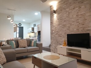 Relax in a cozy seating area with a neutral-toned sofa and flat-screen TV.