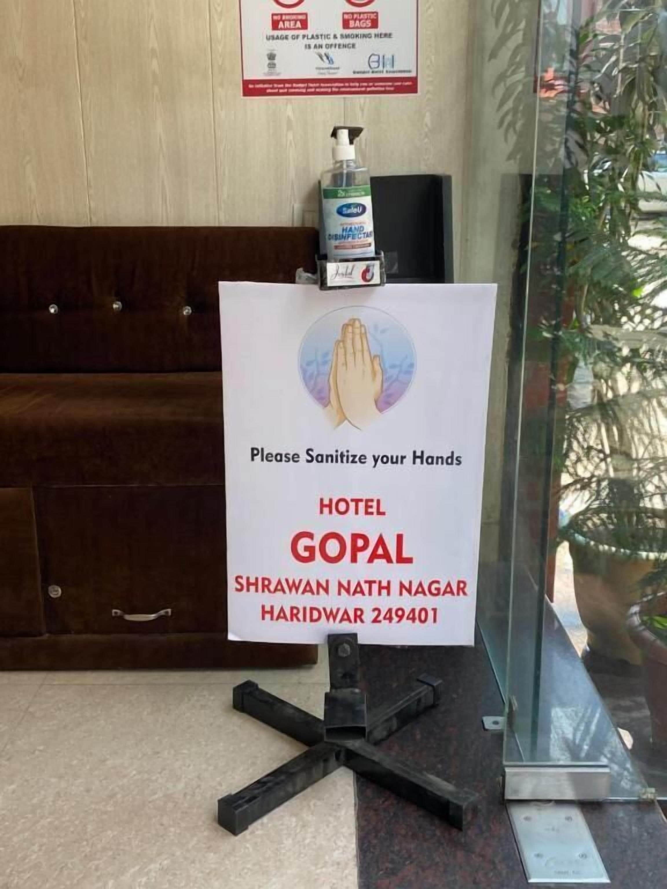 A sign at the entrance of a hotel requesting guests to sanitize their hands.