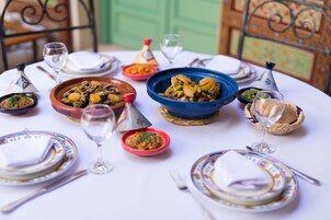 A table set with various dishes, glasses, and a traditional Moroccan tea set.