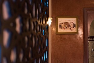 Un corridoio con un pannello decorativo in metallo e un quadro appeso raffigurante una scena storica.