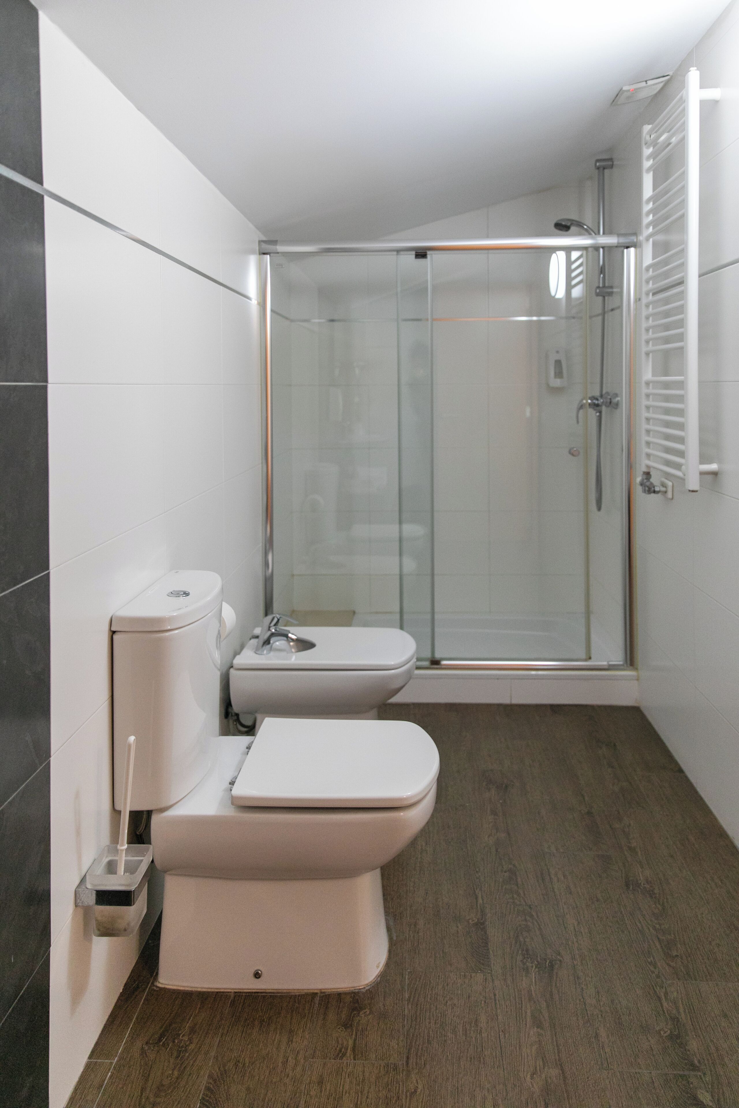 Un baño moderno con ducha de vidrio, inodoro y lavamanos.