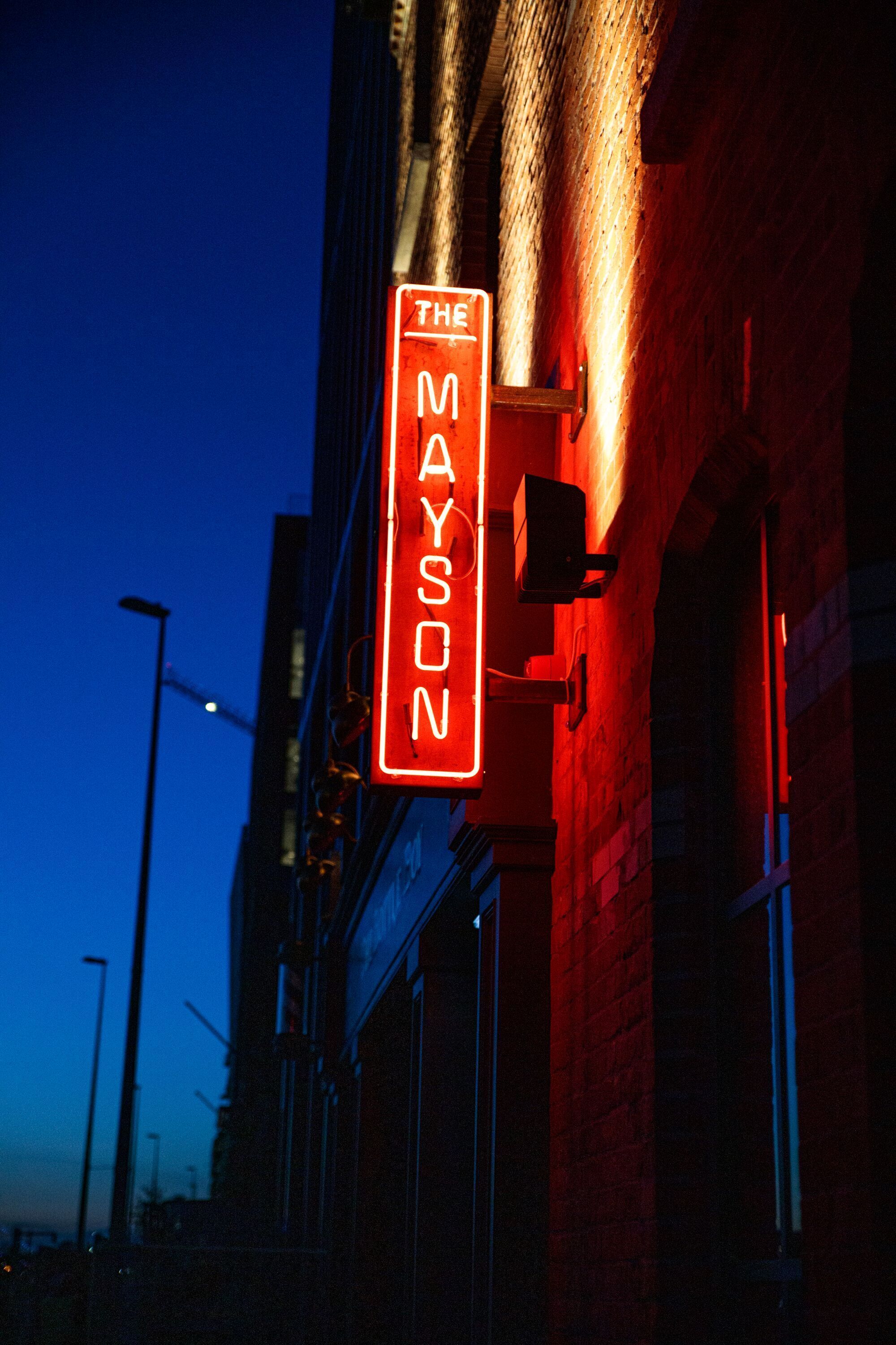 A neon sign on a building at twilight.
