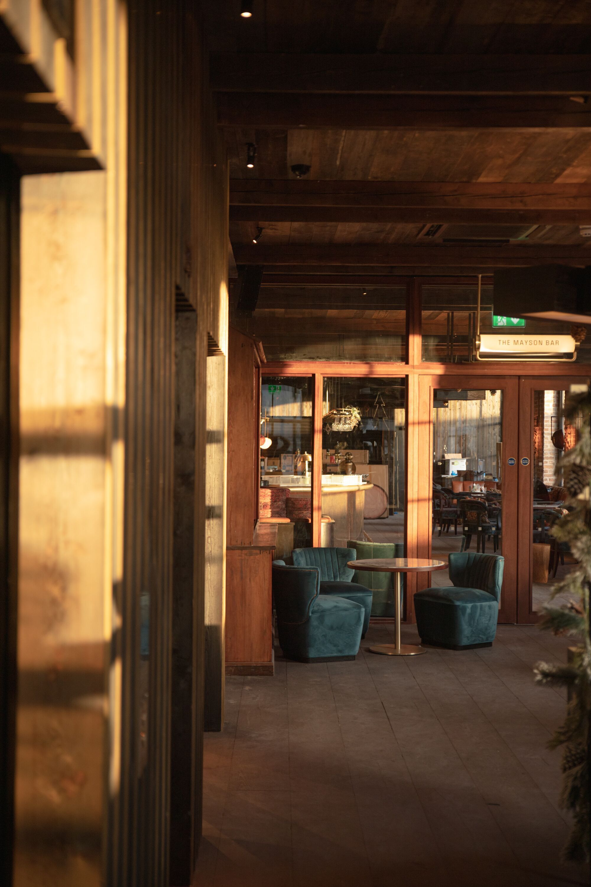 A cozy bar area with wooden beams, a bar counter, and comfortable seating.