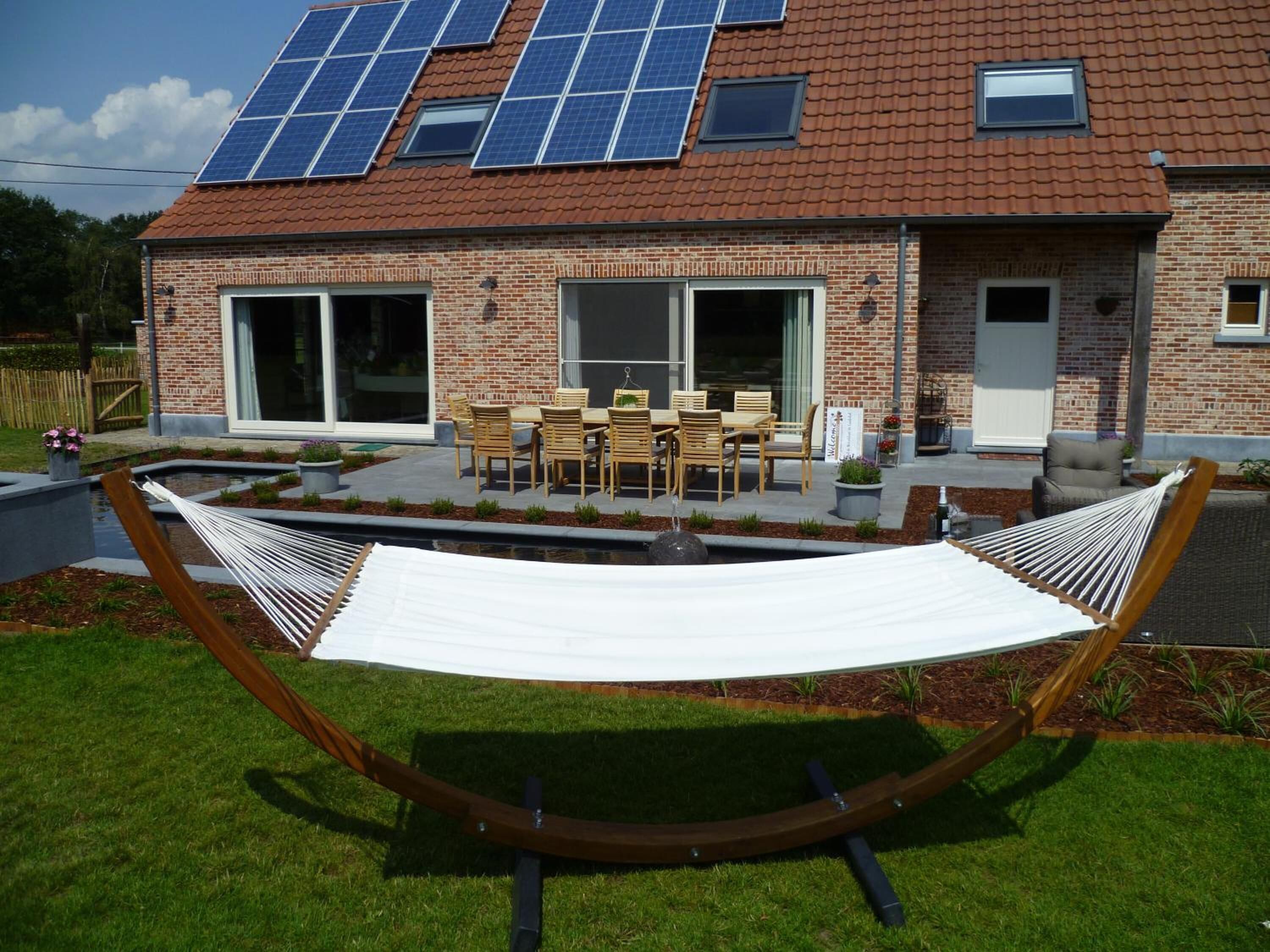 Una casa con fachada de ladrillo, techo de tejas y paneles solares.