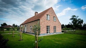 Une maison en briques avec un toit en pente et une pelouse bien entretenue.