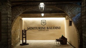 An arched stone corridor with a sign reading "VENTURINI BALDINI RONCOLO 1888". -  Relais Roncolo 1888 - Small Luxury Hotels of the World (Quattro Castella)