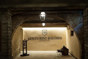 Um corredor de pedra em arco com uma placa que diz 'VENTURINI BALDINI RONCOLO 1888'.