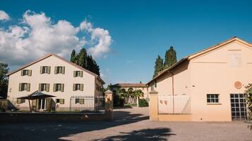 A building with a symmetrical facade, multiple windows, and a gated entrance.