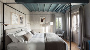 A bedroom with a four-poster bed, a chair, a desk, and artwork on the walls. -  Relais Roncolo 1888 - Small Luxury Hotels of the World (Quattro Castella)