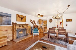 Un salon chaleureux avec une cheminée, des meubles en bois et un coin repas.