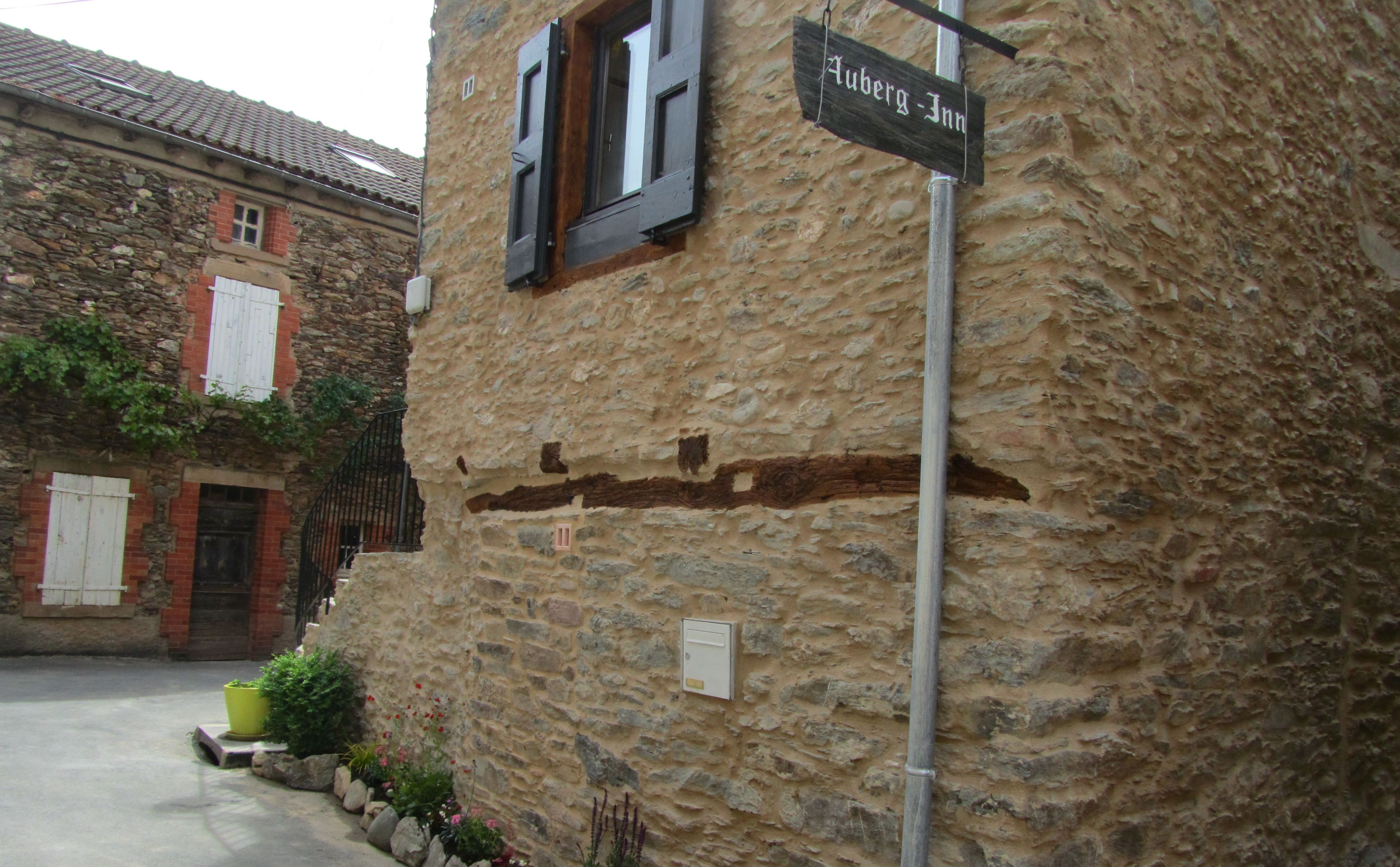 Un edificio de piedra con un letrero que dice "Auberge Inn".