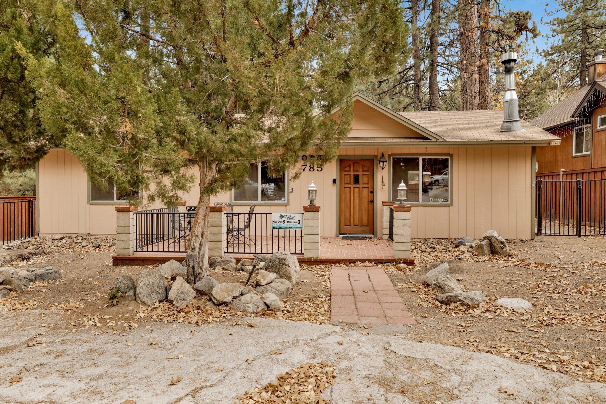 A single-story house with a front porch, a chimney, and a mailbox.