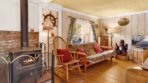 A cozy living room with a fireplace, wooden furniture, and a television.