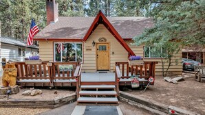 Een chalet met een houten veranda, een brievenbus en een 'Welcome'-bord.