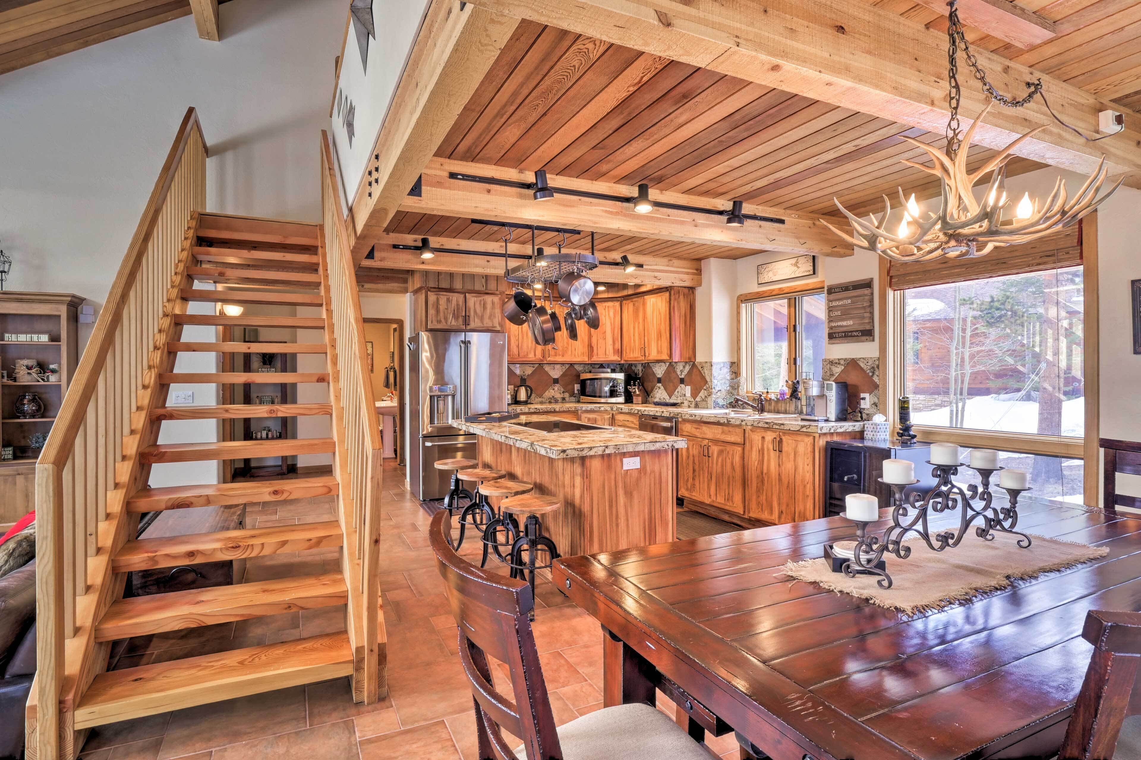 Un'ampia cucina con mobili in legno, una grande isola centrale e un'area pranzo con tavolo e sedie in legno.