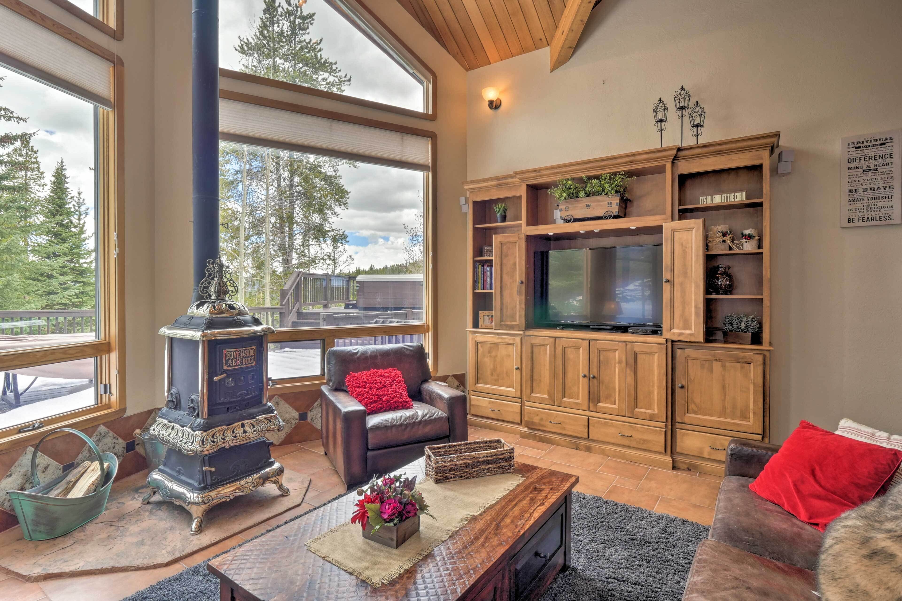 A cozy living room with a fireplace, leather sofa, wooden cabinets, and a television.