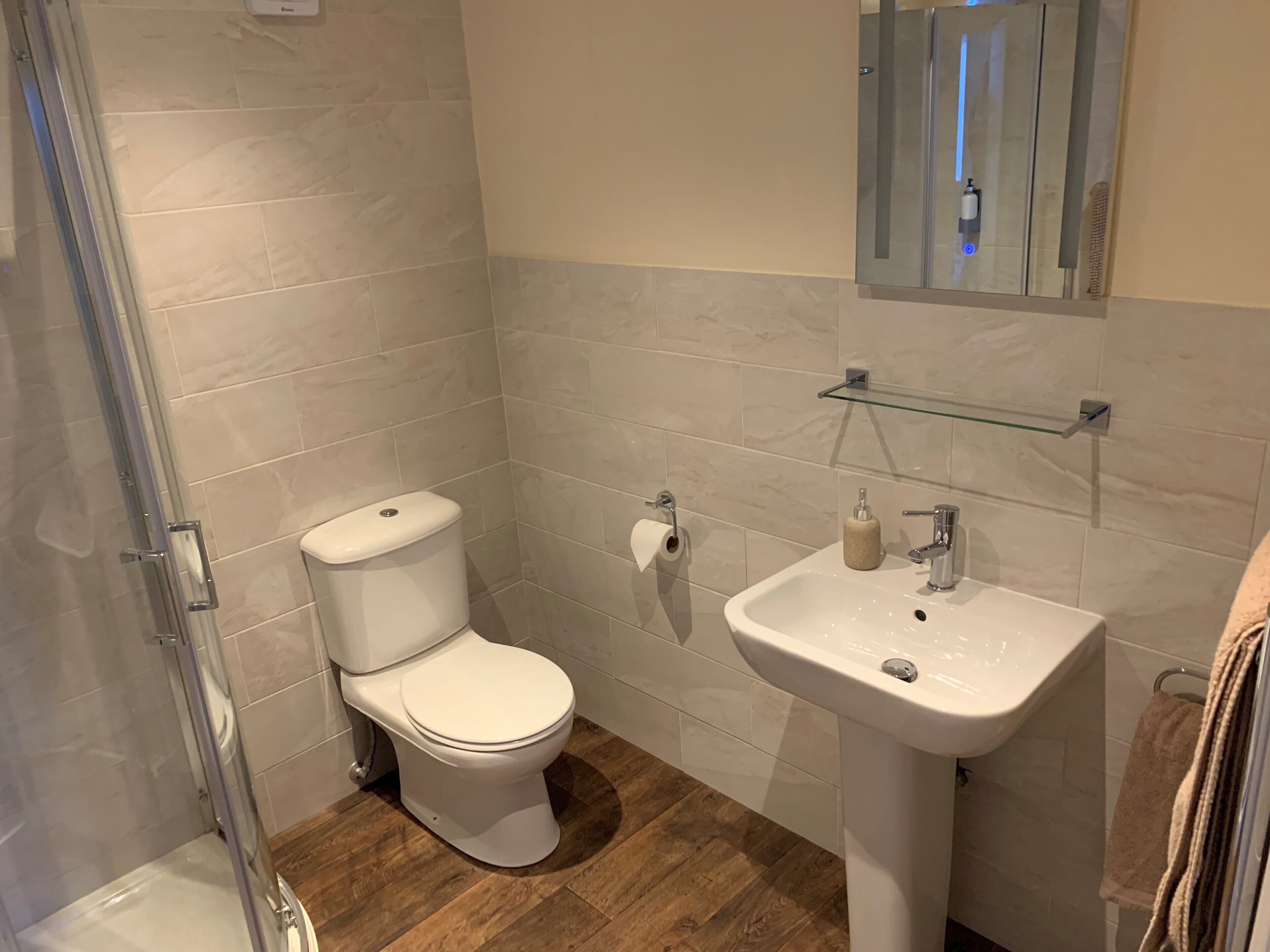 Un bagno con WC, lavandino e cabina doccia in vetro.