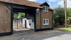 A brick building with a sign reading "Fornham Guest House" and a gated entrance. - Fornham Guest House (Chertsey)
