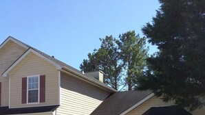 A two-story house with a garage, a front porch, and a small garden with a fountain. - Entertainment 4539 (Snellville)