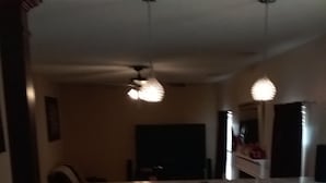 A kitchen with a central island, two bar stools, and pendant lighting. - Entertainment 4539 (Snellville)