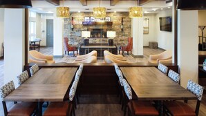Un comedor amplio con una larga mesa de madera y sillas tapizadas con estampado.