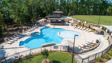 A swimming pool with lounge chairs and a gazebo.