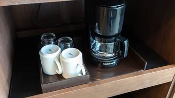 Een lade met een Cuisinart koffiezetapparaat, twee witte mokken en twee kleine glazen bakjes.