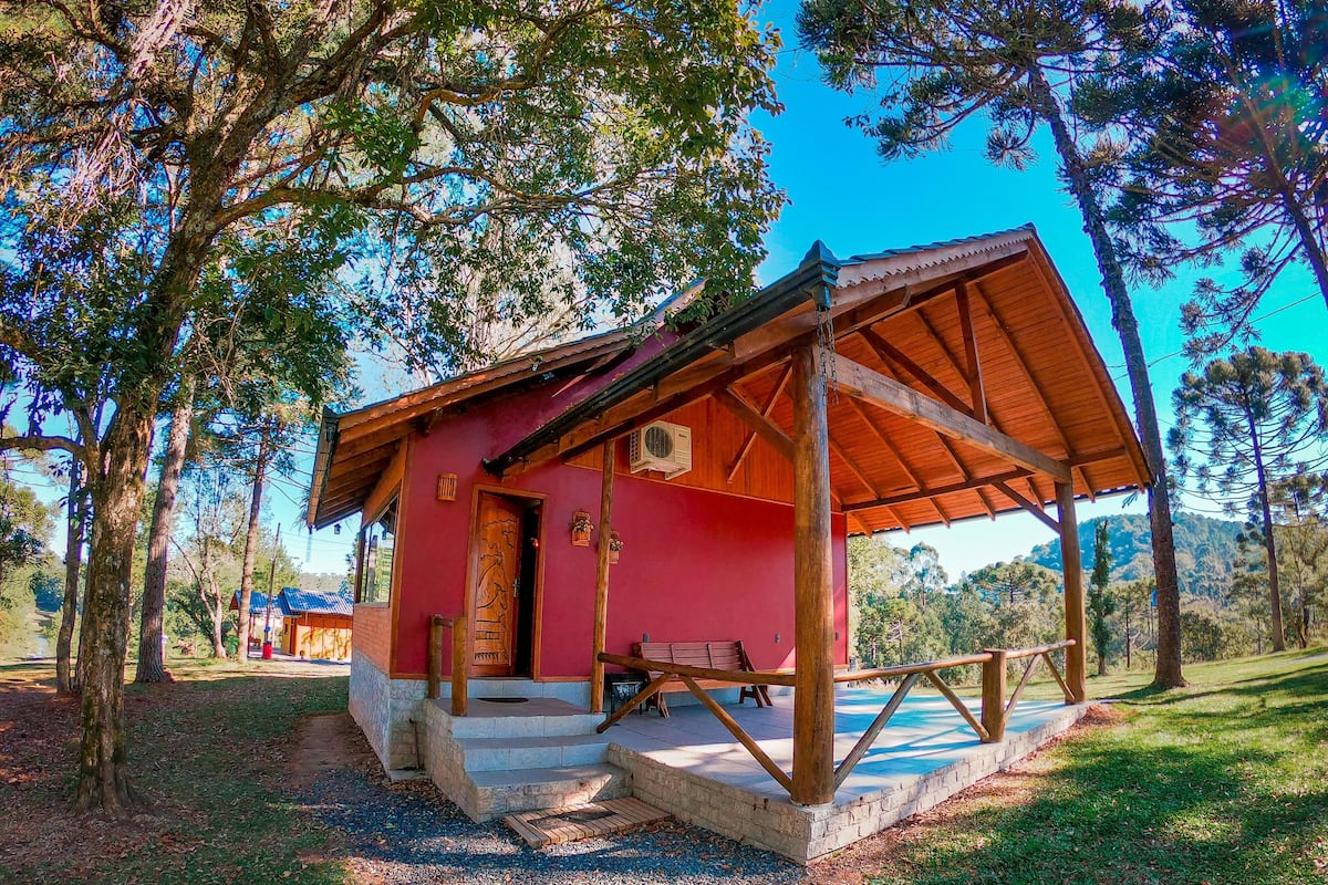 Una cabana petita i rústica amb façana vermella i un porxo de fusta.