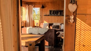 A cozy wooden interior with a bed, a sofa, and a table.