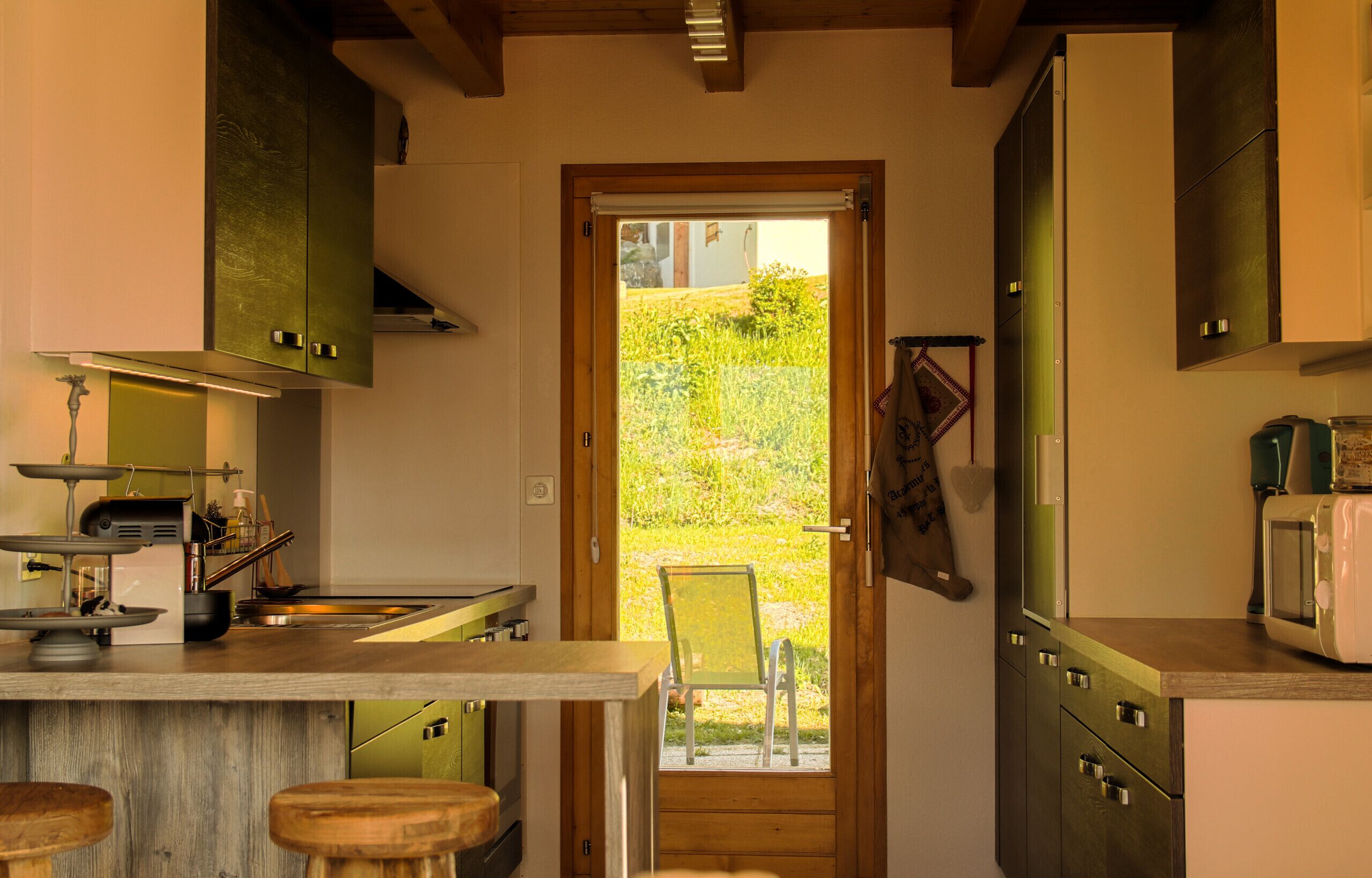Una cocina con puerta de madera que da a un jardín, una balanza y un tostador.
