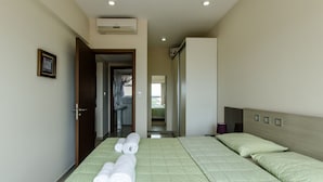 A hotel room with a bed, a bathroom, and a hallway leading to another room. - Quantum Park (Asunción)