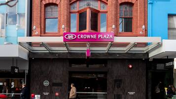 A red brick building with a sign reading "Crowne Plaza."