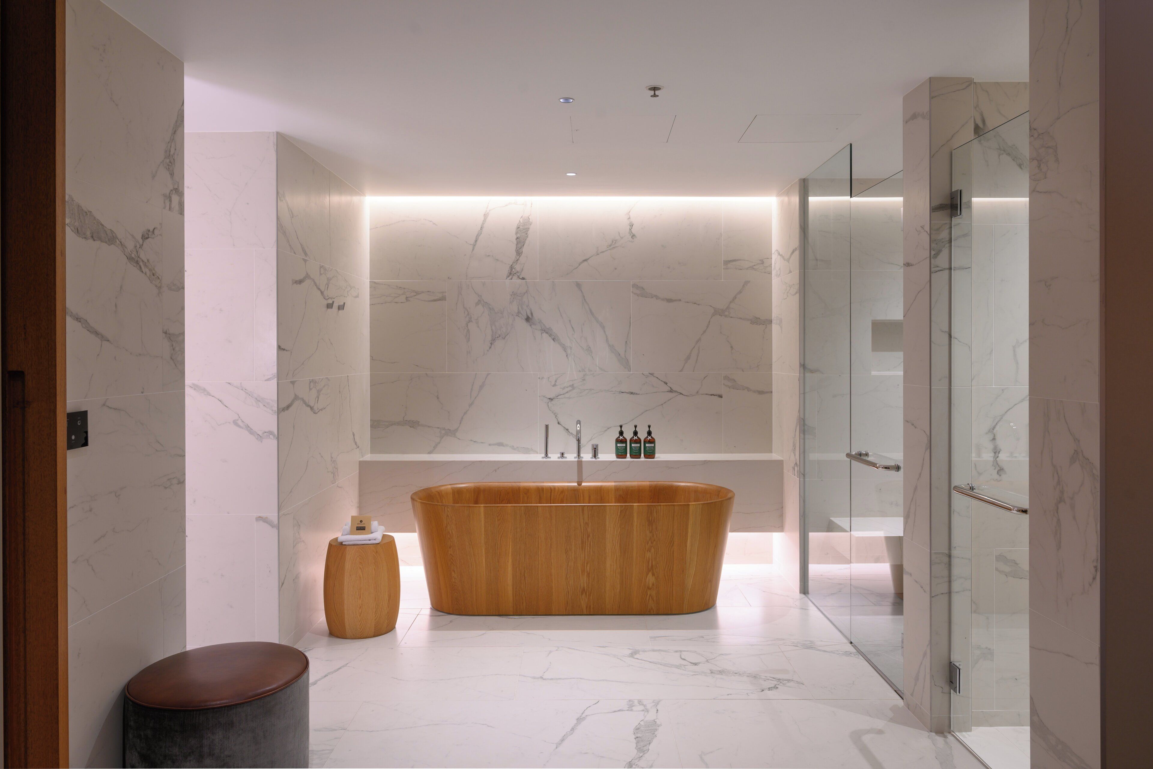 Une salle de bain moderne avec une baignoire sur pieds, une douche en verre et un sol carrelé en marbre.