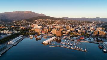 A coastal cityscape with a marina, buildings, and mountains in the background.