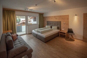 Une chambre à coucher avec un lit, un canapé, une chaise et une tête de lit en bois.