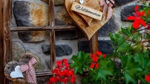 A stone wall with a wooden window frame and a heart-shaped wooden sign with the name 'Wilkommen'. - Rotflüh - Apartments Steffi (Tannheim)