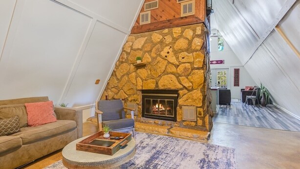 A cozy living room with a stone fireplace, a sofa, and a coffee table.