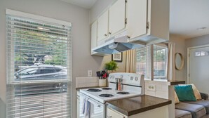 A compact kitchen with white cabinets, a stove, and a countertop. - Enfield #114 xxxxxxx (Austin)
