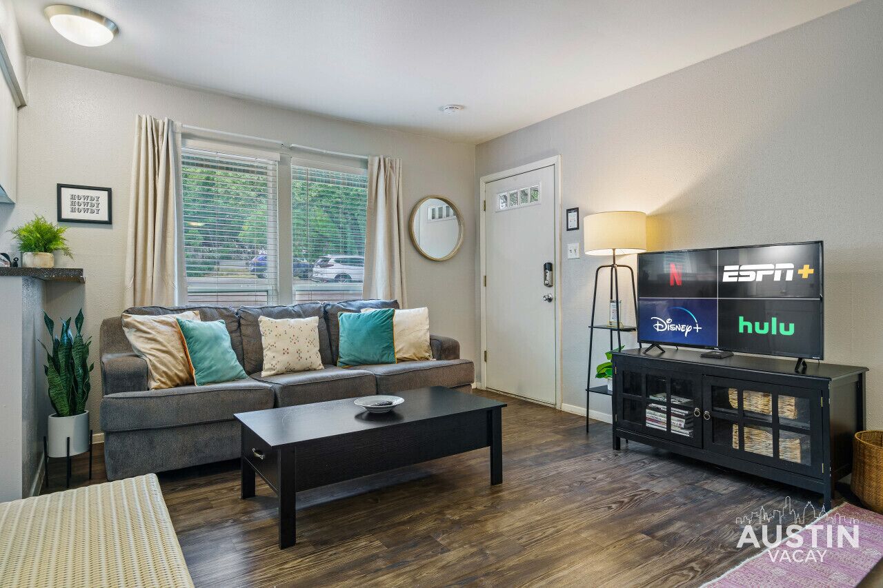 A living room with a sofa, coffee table, and a TV displaying streaming services.