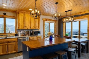 A kitchen with wooden cabinets, a central island, and pendant lighting.