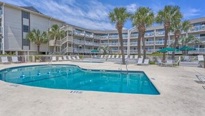 A hotel with a pool area, multiple balconies, and palm trees. - Breakers 102 (Hilton Head Island)